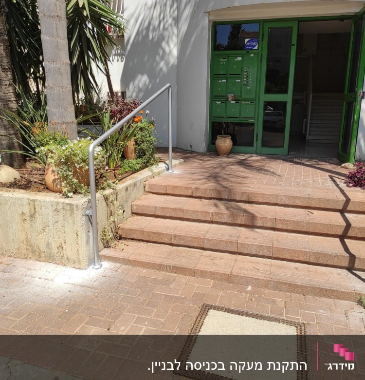 מעקה מתכת ליד מדרגות כניסה לבניין